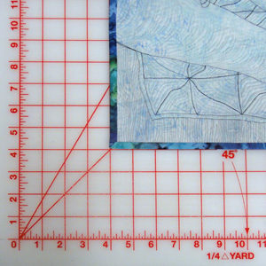 Place quilt face down 4" from edge of cutting mat.